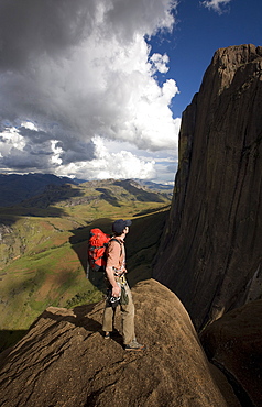 A climber looks up towards the 800 metre Tsaranoro Be (Big Tsaranoro) Monolith, Andringitra National Park, Southern Madagascar, Africa