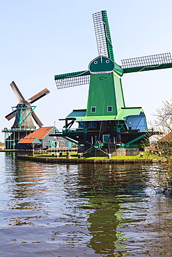 Preserved historic windmills and houses in Zaanse Schans, a village on the banks of the river Zaan, near Amsterdam, it is a popular tourist attraction and working museum, Zaandam, North Holland, Netherlands