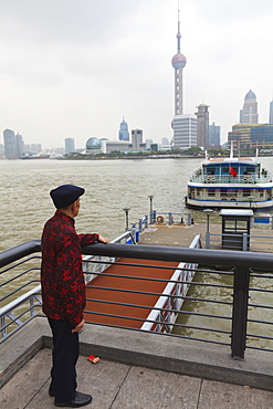 A man watching ferries crossing the Huangpu River, Shanghai, China, Asia