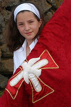 Girl carrying a banner in a Catholic procession during Espiritu Santo Festival in Vila Novo, Terceira, Vila Nova, Azores, Portugal, Europe