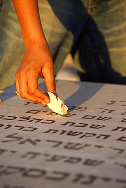 Boy placing stone on a grave in the Mount of Olives Jewish cemetery, Jerusalem, Israel, Middle East