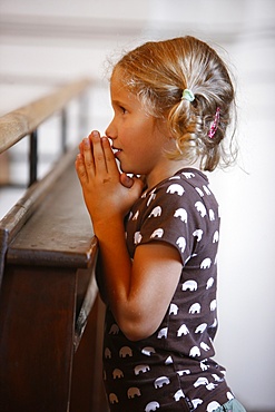 Girl praying in church, Saint Nicolas de Veroce, Haute Savoie, France, Europe