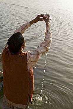 Hindu performing his daily devotion ritual to Ganga in Varanasi, Uttar Pradesh, India, Asia