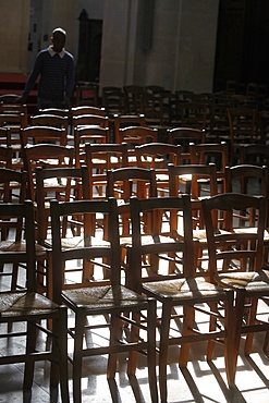 Layman tidying chairs, Saint Jacques du Haut Pas church, Paris, France, Europe