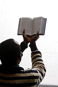 African man reading the Bible in a church, Paris, France, Europe