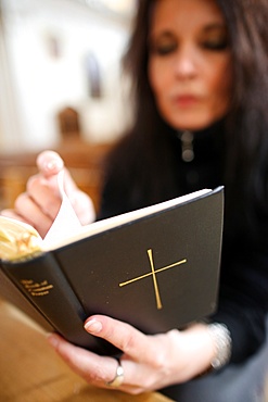 Woman reading the Bible in a church, Haute-Savoie, France, Europe