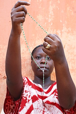 African woman praying the rosary, Lome, Togo, West Africa, Africa