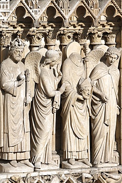 Detail of St. Denis holding his head flanked by two angels, Virgin portal, Western facade, Notre Dame de Paris Cathedral, Paris, France, Europe