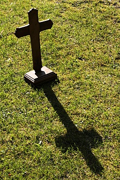 Shadow of a wooden cross on the lawn, St. Gervais-les-Bains, Haute-Savoie, France, Europe