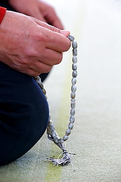 Man praying in a mosque with Tasbih (prayer beads), Bussy-Sainte-Georges, Seine-et-Marne, France, Europe