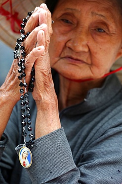 Old Vietnamese woman praying with prayer beads, St. Philip Church (Huyen Sy Church), Ho Chi Minh City, Vietnam, Indochina, Southeast Asia, Asia