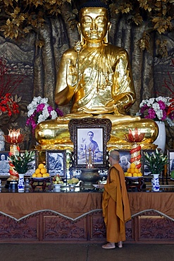 Golden Buddha with lotus flower and Buddhist monk, Minh Dang Quang Buddhist Temple, Ho Chi Minh City, Vietnam, Indochina, Southeast Asia, Asia