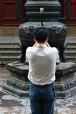 Prayer with incense in the Shanghai White Jade Buddha temple, Shanghai, China, Asia