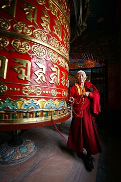 Woman and prayer wheel, Bodhnath Stupa, Kathmandu, Nepal, Asia