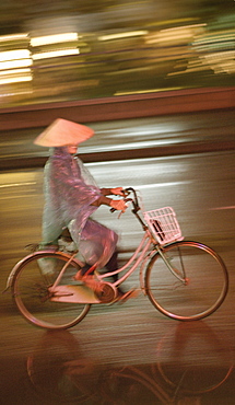 Woman on bicycle in rain, Vietnam, Indochina, Southeast Asia, Asia