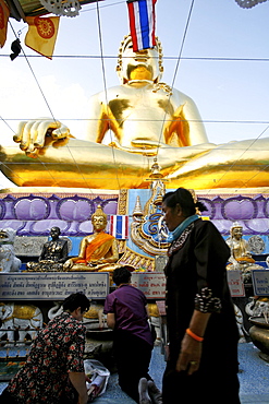 People praying below the giant Buddha, in Sop Ruak temple, close to the border with Burma and Laos, Thailand, Southeast Asia, Asia