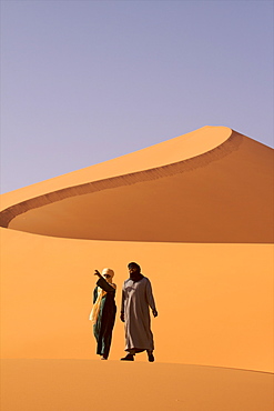 Two Tuaregs in the dunes of the erg of Murzuk in the Fezzan desert, Libya, North Africa, Africa