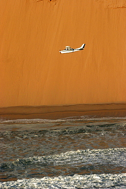 A small Cessna flying between the ocean and the desert, Skeleton Coast, Namibia, Africa