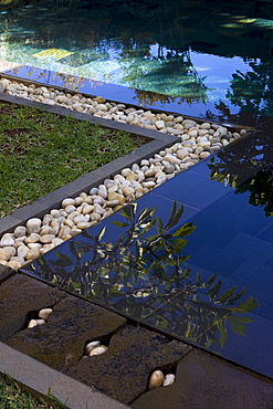 Outdoor dark tiled pool with edging of stone and pebbles, Baie aux Tortues, Pointe aux Pimentes, Mauritius, Africa