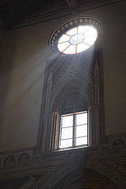 Rays of light burst through a circular stained glass window, Santa Croce, Florence, Tuscany, Italy, Europe