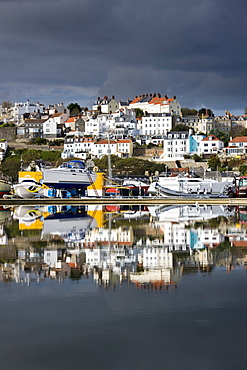 St. Peter Port and harbour side boats stored on dry dock reflected in a model boat pond in Guernsey, Channel Islands, United Kingdom, Europe