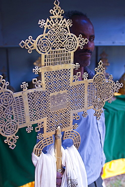 Orthodox monk standing behind a Christian cross, Axum, Ethiopia, Africa