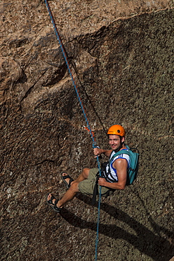 Tourist hanging on a rope while Canyoning in the area of the Slickrock Trail, near Arches National Park, Moab, Utah, United States of America, North America