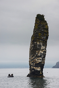 Little tourist boat ships beside a large monolith in the Avacha Bay near Petropavlovsk-Kamchatsky, Kamchatka, Russia, Eurasia