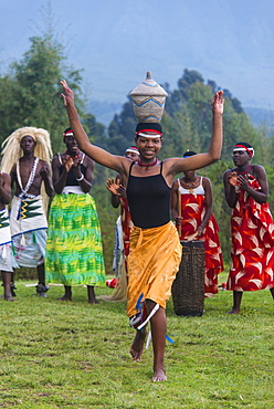 Woman carrying a basket on her head at a ceremony of former poachers, in the Virunga National Park, Rwanda, Africa