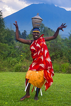 Woman carrying a basket on her head at a ceremony of former poachers, in the Virunga National Park, Rwanda, Africa