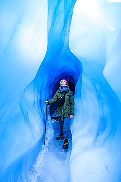 Woman standing in an ice cave, Fox Glacier, Westland Tai Poutini National Park, South Island, New Zealand, Pacific