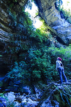 Woman looking at the stunning Oparara Arch in the Oparara Basin, Karamea, West Coast, South Island, New Zealand, Pacific