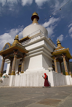 Pilgrim circling a white Stupa with prayer wheel in hand, Thimpu, Bhutan, Asia