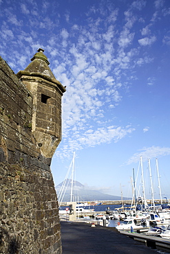 Muralhas de Sao Sebastiao (walls of St. Sebastian), fortress constructed to defend the bay of Porto Paim, and the marina, Horta, island of Faial, with Pico mountain on the island of Pico in the distance, Azores, Portugal, Atlantic, Europe