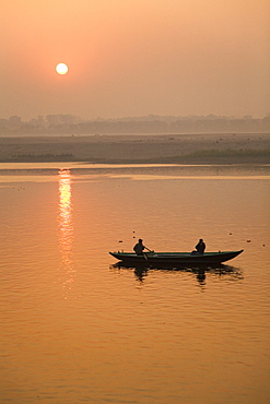 A photographer takes a photo from a rowing boat on the Ganga (Ganges) River at Varanasi, Uttar Pradesh, India, Asia