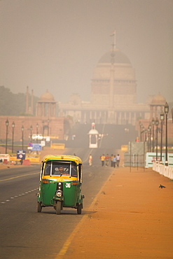 An auto rickshaw drives along the Rajpath, in front of the Rashtrapati Bhavan (President's Palace), on a hazy day in New Delhi, India, Asia