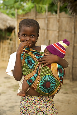 Child carrying baby in Guludo village in the Quirimbas National Park in northern Mozambique, Africa