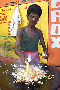 Man cooking South Indian style scrambled eggs at a roadside dhaba in Pondicherry India