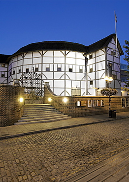 Dusk view of Shakespeare's Globe theatre on the banks of the Thames river in London.