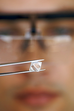 An uncut diamond being examined during sorting at De Beers' Harry Oppenheimer House building in Kimberley South Africa.