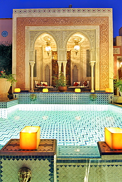 Dusk view of the pool and relaxation area in the Palais Sebban riad in Marrakech, Morocco