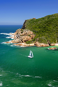 A catamaran sails through The Heads, the entrance to the Knysna lagoon on the Garden Route in South Africa.