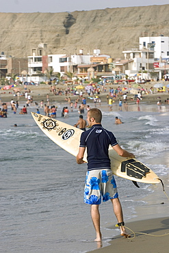 Surfer at the popular far north coast fishing & surfing village of Huanchaco, near Trujillo, Peru, South America.