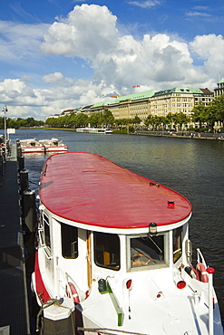 One of the tour boats that ply the popular Alster Lake, moored at the Jungfernstieg with the Ballindamm beyond, Hamburg, Germany, Europe 