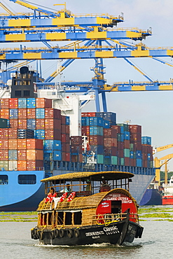 Tourist boat near container ship and cranes at Vallarpadam Container Terminal, a major Indian port, Kochi (Cochin), Kerala, India, Asia