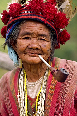 Portrait of an elderly woman of the Ifugao tribe wearing a woven hat decorated with feathers and carved bird at Banaue, Mountain Province, north Luzon, Philippines, Southeast Asia, Asia