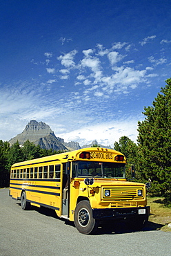 Yellow school bus, for students on geology field trip, Waterton Glacier International Peace Park, Rocky Mountains, Montana, United States of America, North America