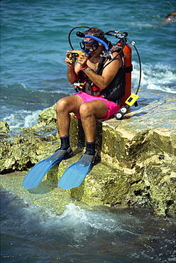 Man preparing to dive at Chankanaab Park, famous for its superb coral reef, on the island of Cozumel, off the Yucatan Peninsula, Mexico, North America