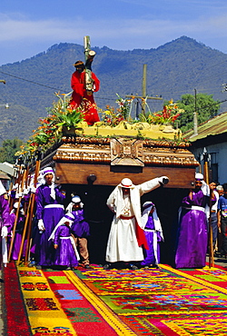 Men carry a huge wooden float of Christ over coloured sawdust carpet during the Easter procession in Antigua, Guatemala, Central America