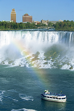 Tourists on small sightseeing boat below the American Falls on the Niagara River that flows between Lakes Erie and Ontario, Canada, North America